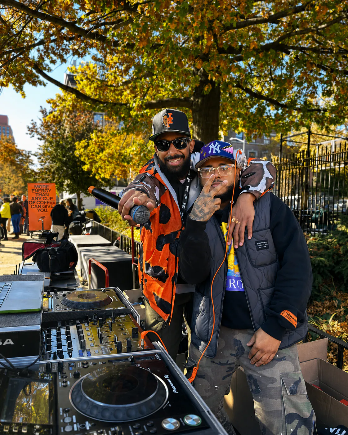 DJ Alaska posing by DJ equipment at an outdoor event