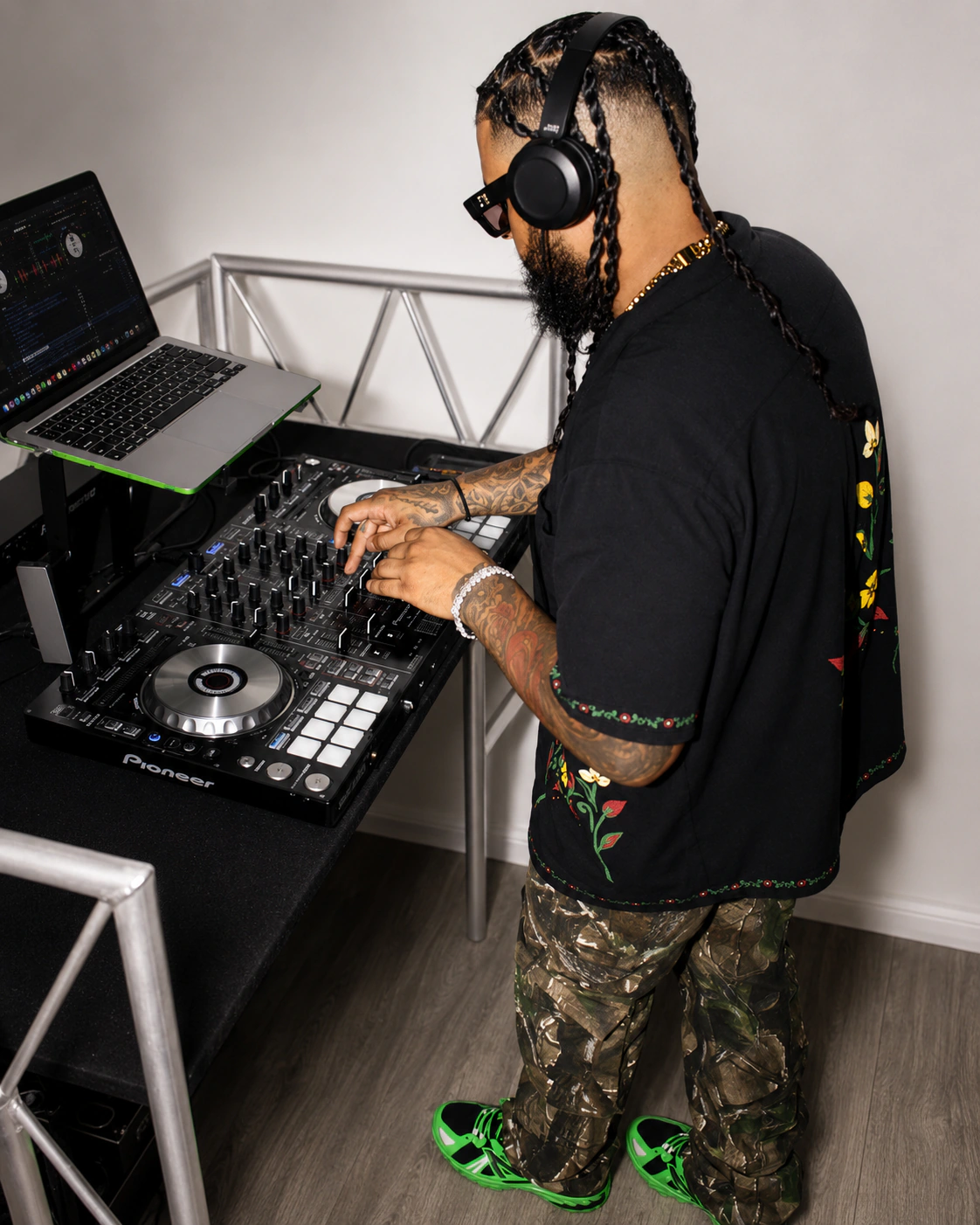 DJ Alaska mixing on a Pioneer controller while wearing headphones