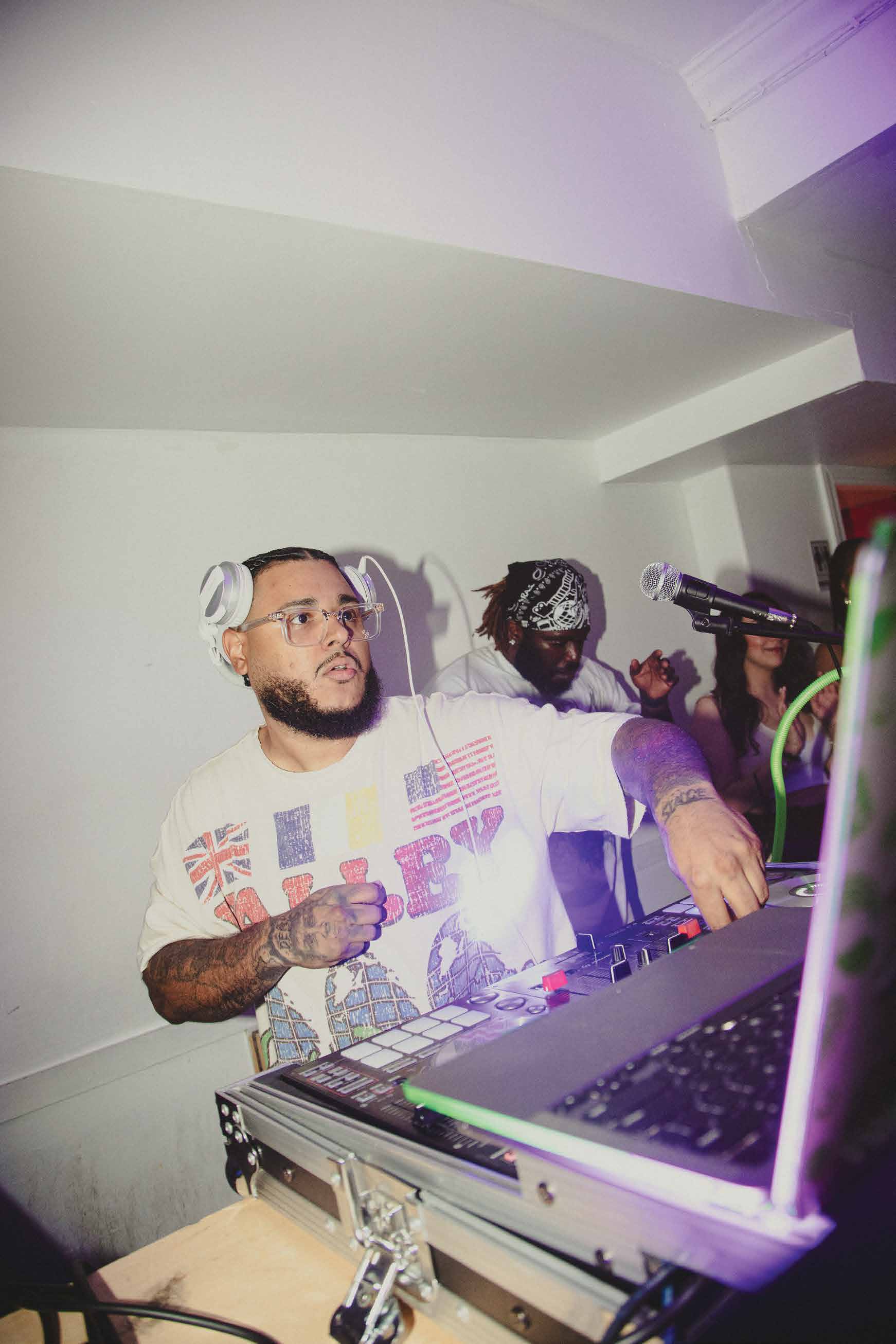 DJ Alaska performing live on a controller, crowd behind him